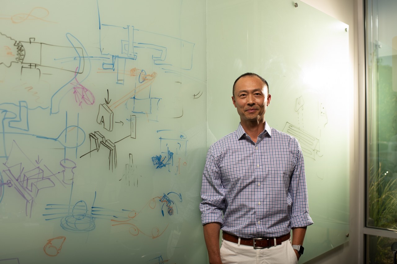 A Foundry partner standing beside a whiteboard covered in device sketches
